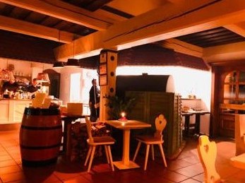 Gemütlicher Gastraum der Taverna mit Holzofen und Weinfässern